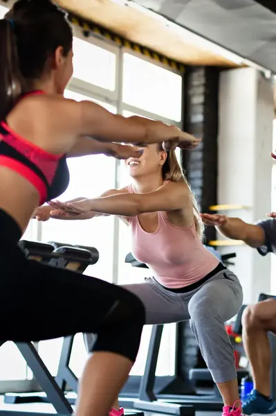 Fitness klasje, de sporters doen een squat oefening.
