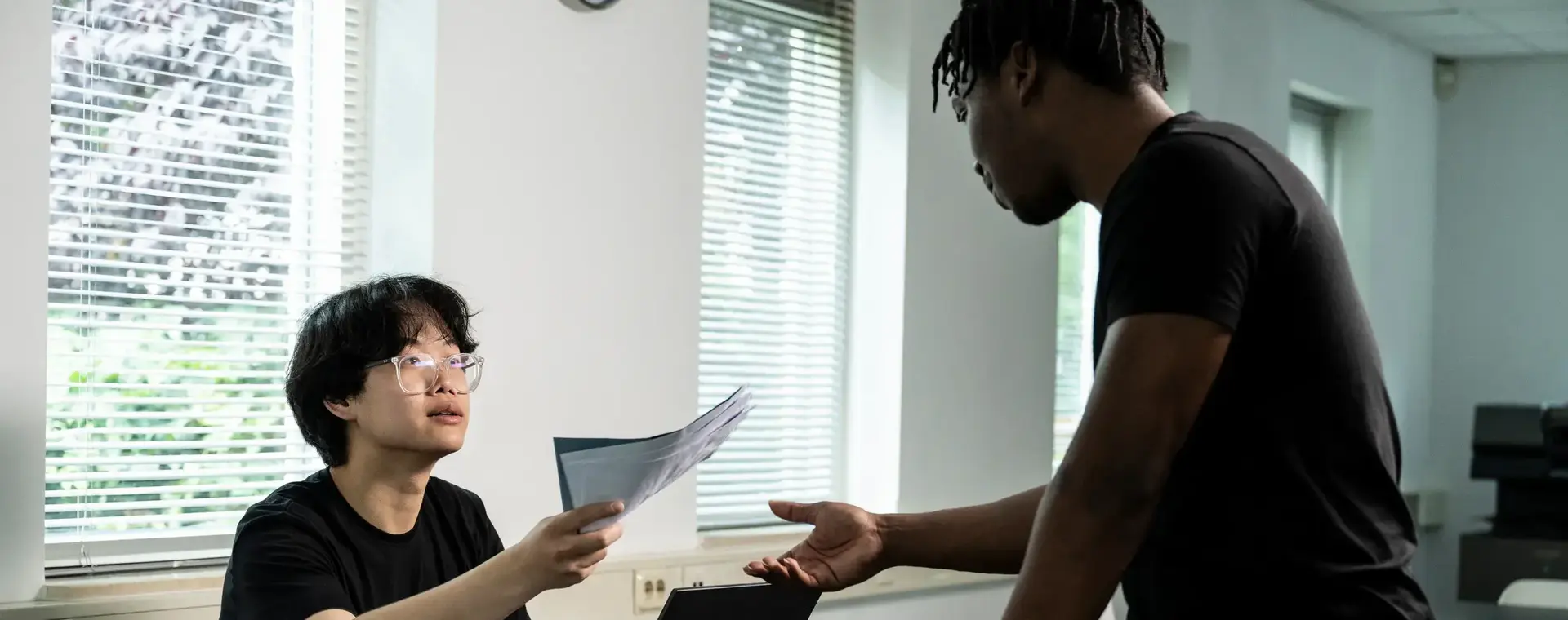 Student overlegt en wisselt documenten uit met een medestudent