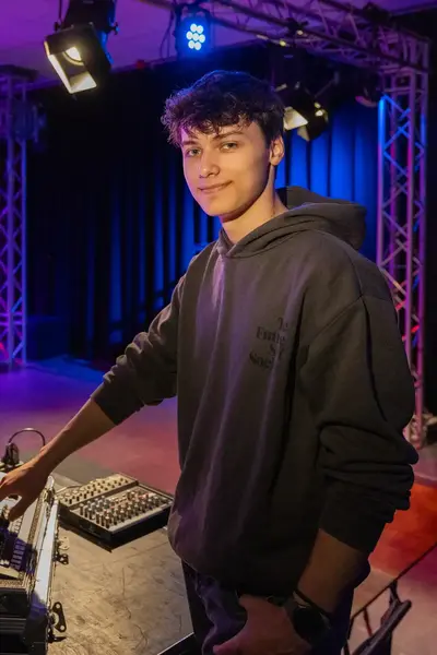 Student met lichtmengpaneel achter in de toneelzaal .