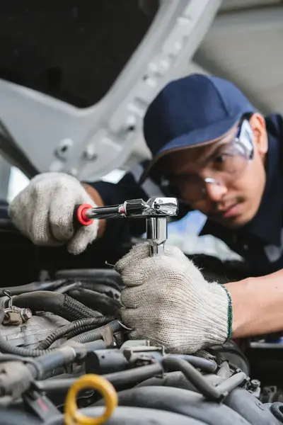 Student repareert onderdeel van automotor in werkplaats