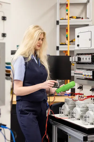 Student meet elektrotechnische installatie door in machinekamer.
