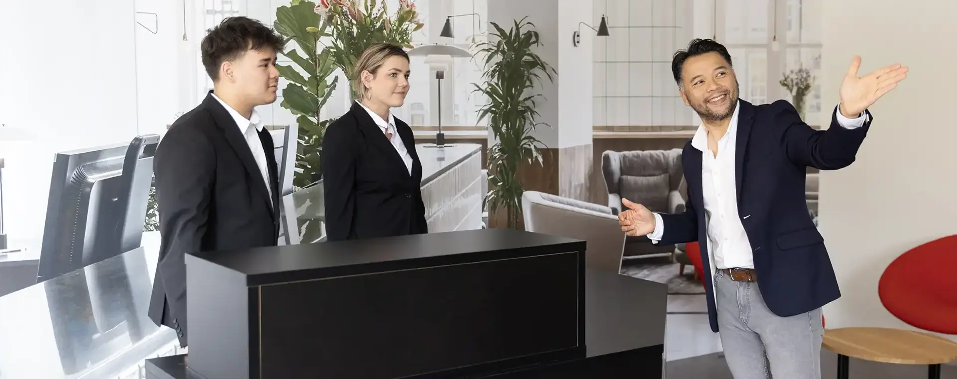 Manager wijst iets aan voor twee receptiemedewerkers