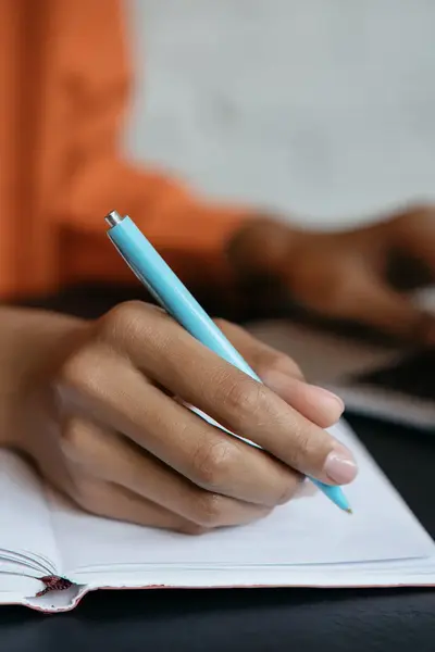 Student schrijft in een schrift.