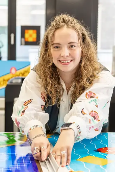 Studente snijdt met een stanleymes een poster op maat.