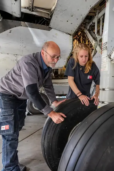 Student en docent checken landingsgestel vliegtuig