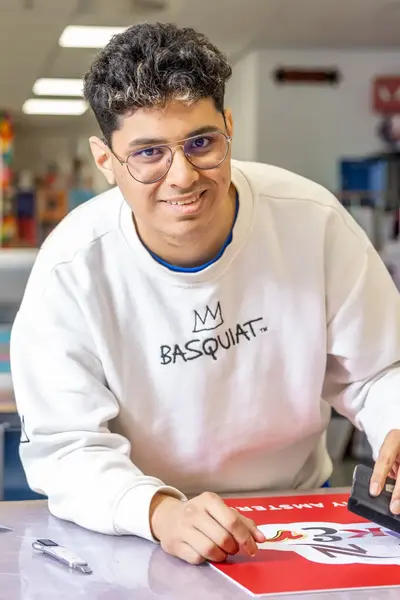 Student is in een praktijklokaal een poster aan het maken