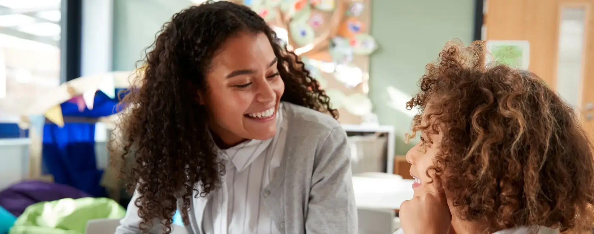 Jonge dame aan een kindertafel met jong kind