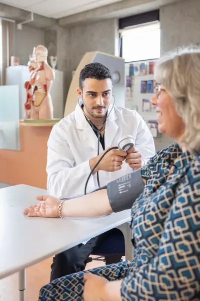 Dokter meet bloeddruk in huisartsenpraktijk