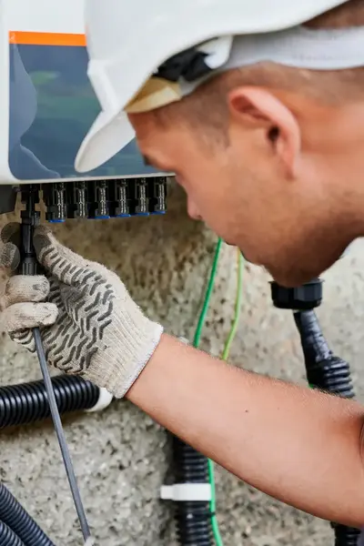 Elektromonteur met bouwhelm installeert elektrotechnische installatie