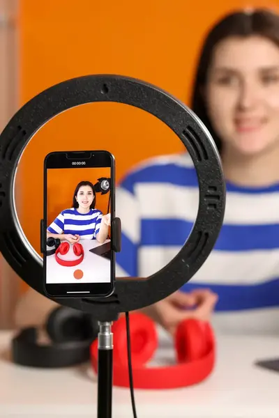 Meisje met mobiele telefoon en ringlight die een social media filmpje van zichzelf aan het maken is.