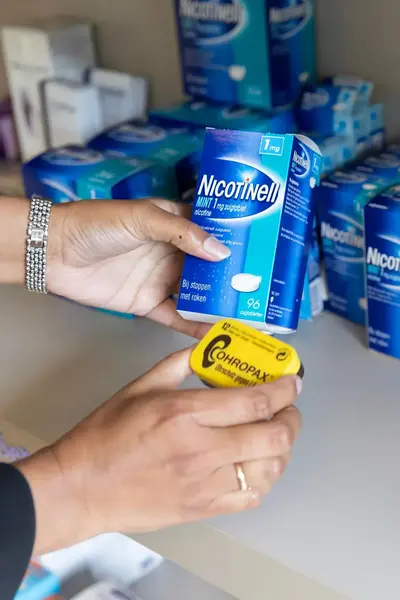 Apotheker zet producten in schappen apotheek
