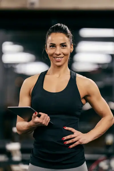 Gespierde dame met tablet in sportschool
