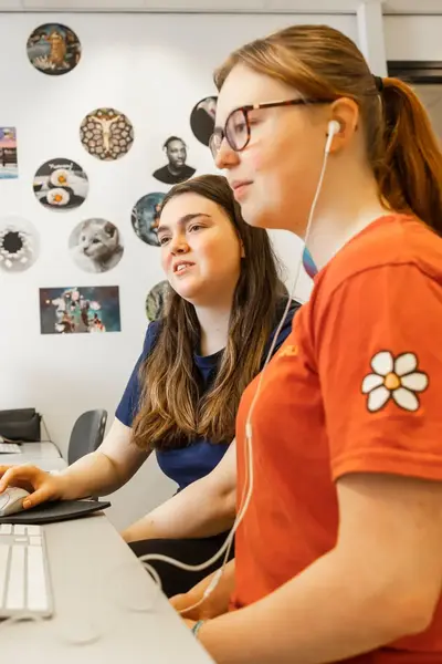 Twee studenten zitten samen achter een Imac te werken