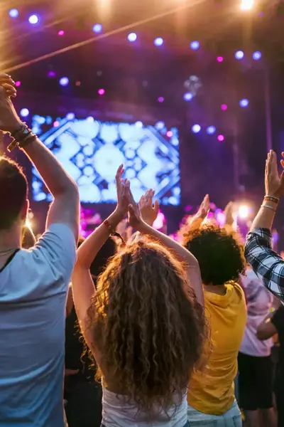 Een grote groep klappende mensen voor een podium bij een groot event