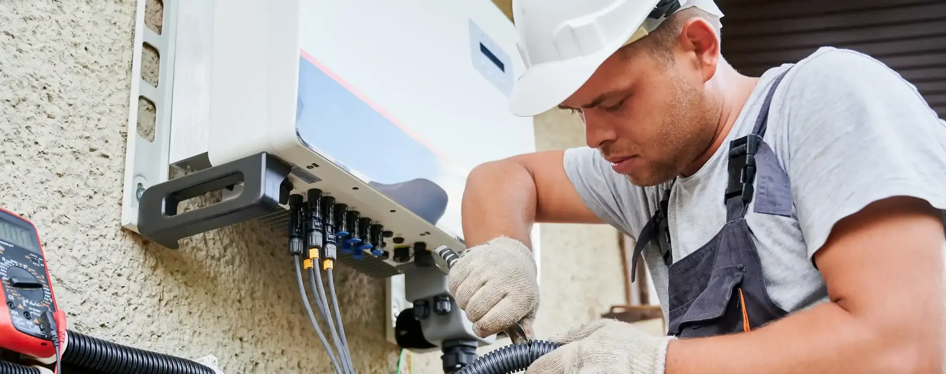 Reparateur herstelt slang aan apparaat buitenmuur