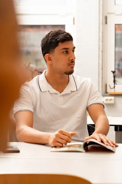 Student in klas met opengeslagen voor boek zich
