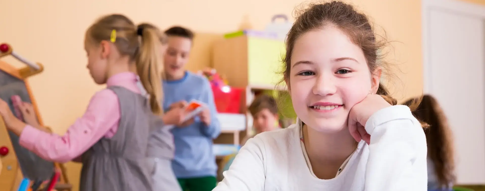 Meisje met op achtergrond kinderen in een klas