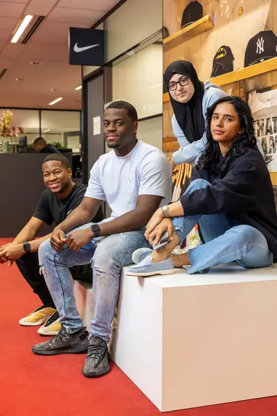 Vier studenten zitten lachend in de school.
