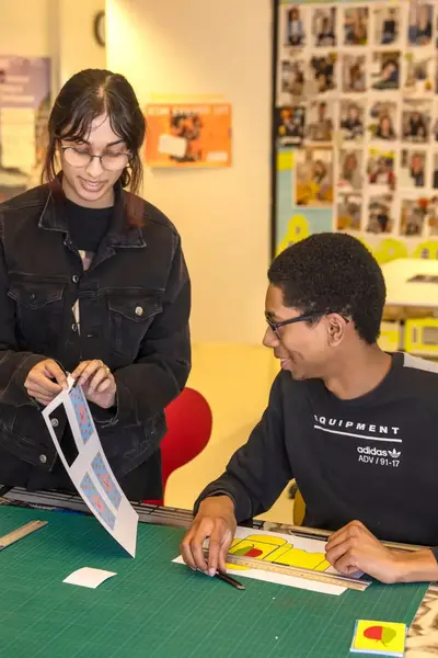 Student bekijken samen een vel foto's.