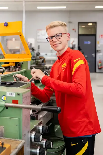 Student sleutelt aan machine in werkplaats
