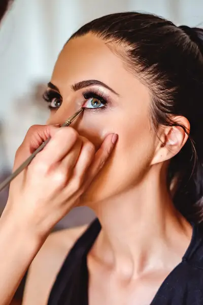 Studente brengt eyeliner aan bij model