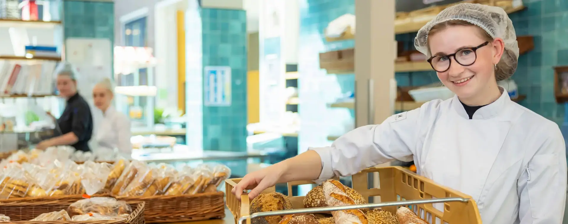 Een bakker presenteert versgebakken brood in de winkel