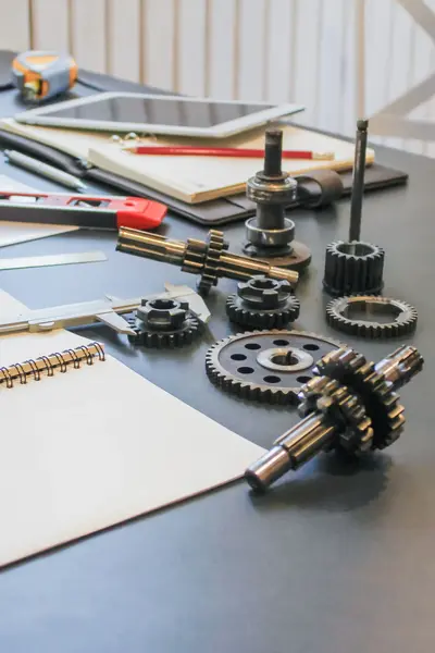 Tandwielen op tafel naast schrift