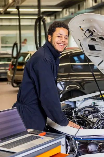 Student helpt met onderhoud aan een auto in de werkplaats