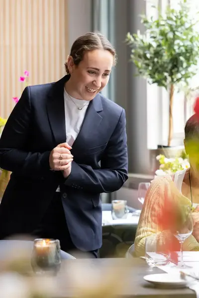 Student Hospitality bekommert zich om gast in restaurant.