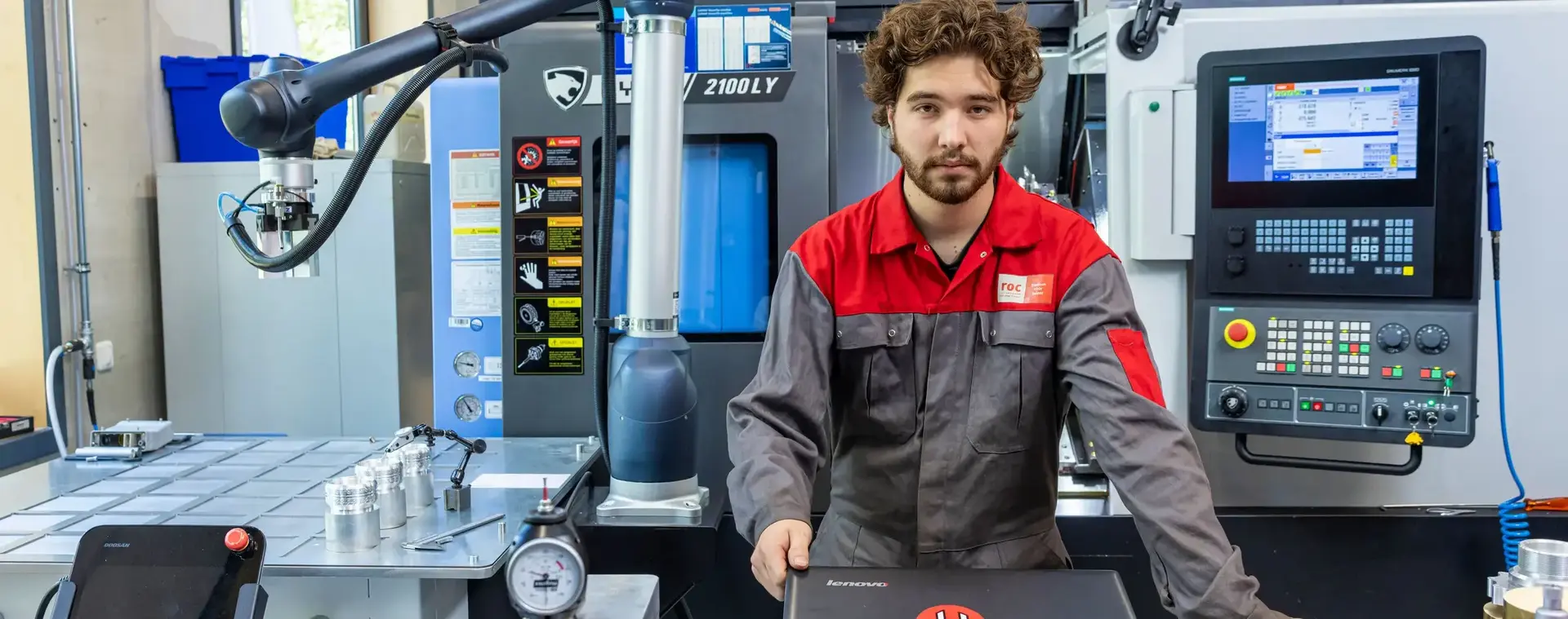 Student staat achter laptop omringd door technische apparatuur