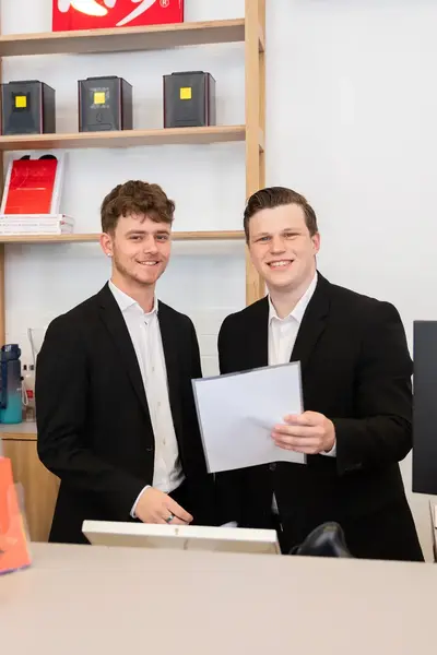 Twee studenten ontvangen gasten bij de hotel receptie