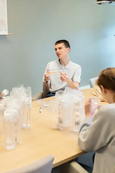 Vijf studenten zitten samen aan tafel.