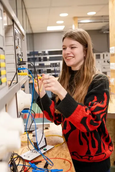 Student sleutelt aan elektrotechnische installatie in leslokaal