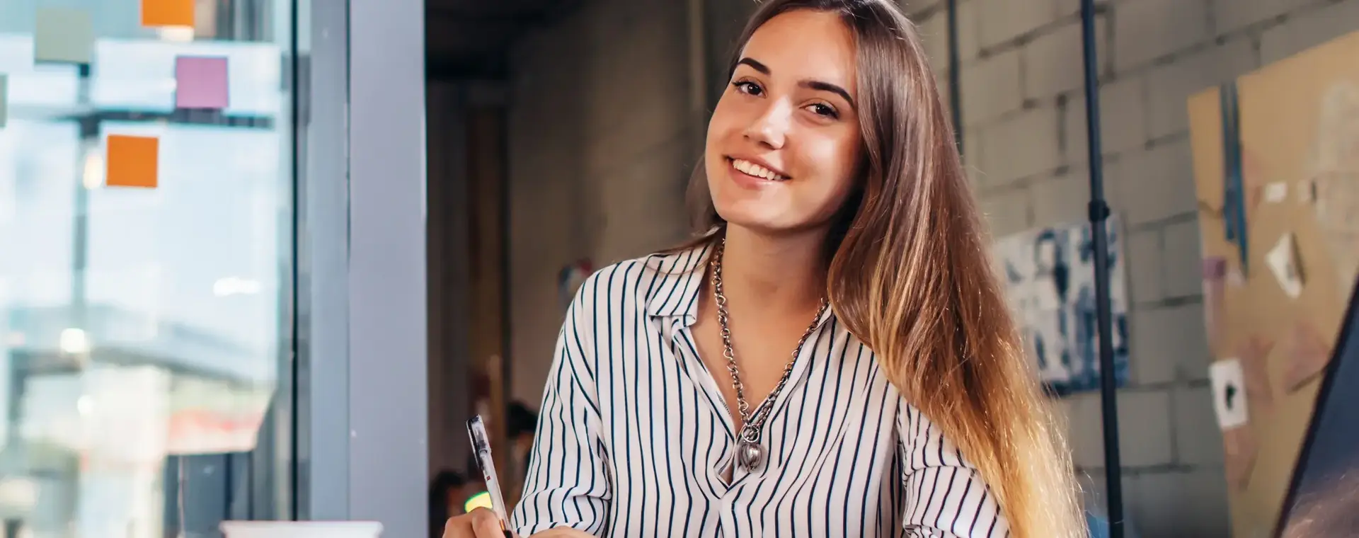 Studente achter bureau schrijft op kladblok 