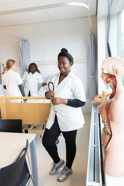 Verpleegster in een ziekenhuis met stethoscoop en collega's