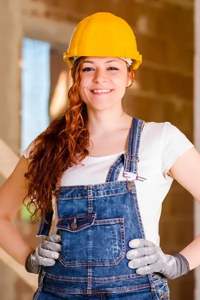 Vrouw met bouwhelm op bouwplaats