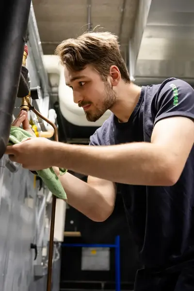 Student sleutelt aan machine in machinehok